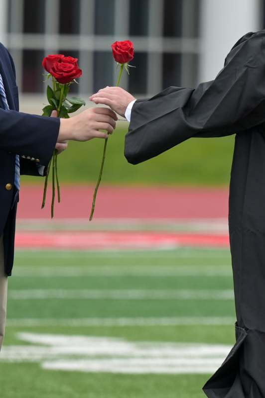 a man giving a rose to another man