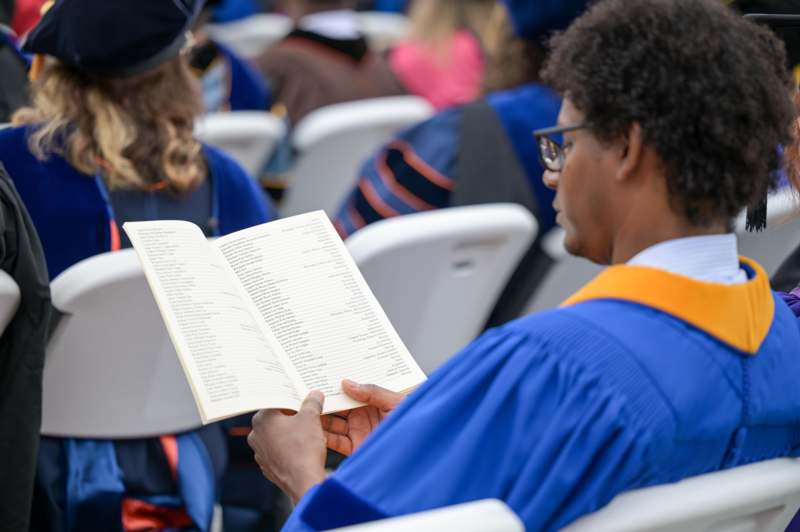 a man in blue gown reading a book