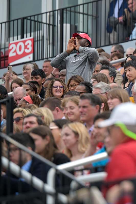 a man covering his mouth with his hands in a crowd of people