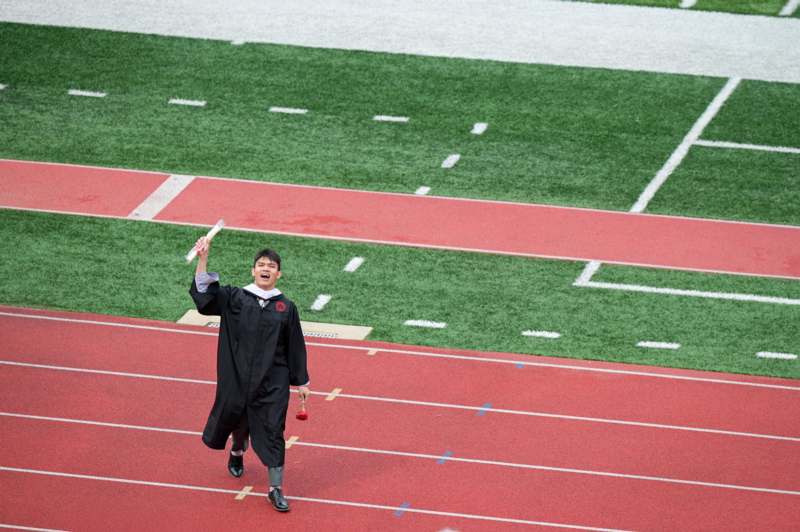 a man in a graduation gown holding a diploma