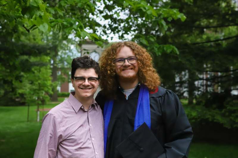two men standing together outside