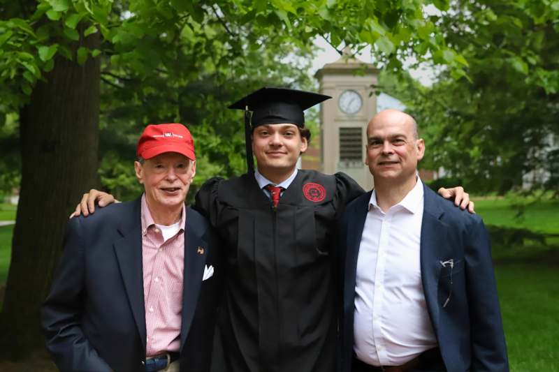 a man in a cap and gown with a man in a red cap and a man in a red cap and a man in a red cap and a man in a black cap and gown standing next