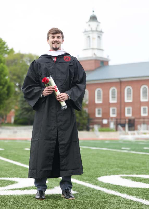 a man in a graduation gown holding a diploma