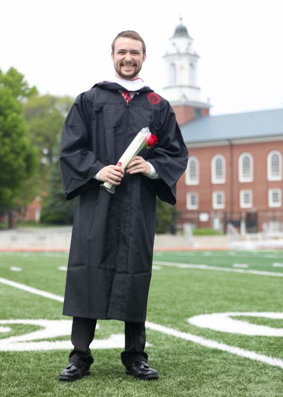 a man in a graduation gown holding a diploma
