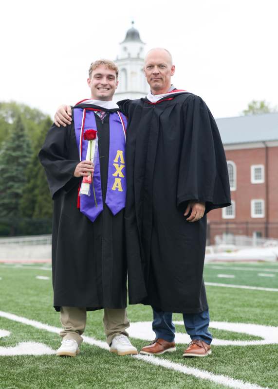 a man in black gowns and a purple robe with a red rose and a red rose