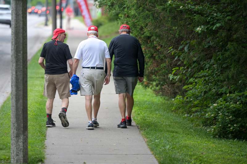 a group of men walking on a sidewalk