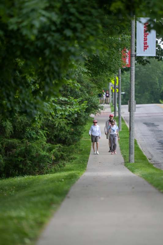 a group of people walking on a sidewalk