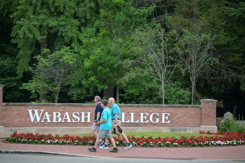 a group of men walking in front of a sign