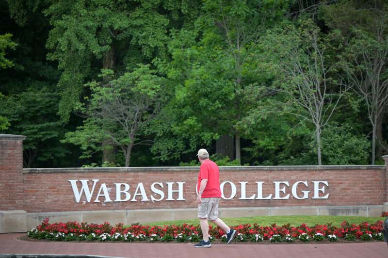 a man walking in front of a sign