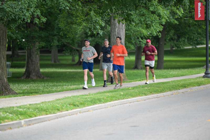 a group of men running on a sidewalk