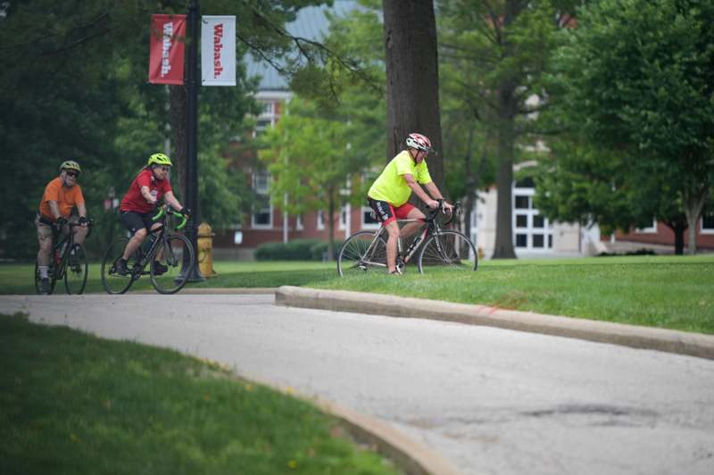 two people riding bicycles on a path