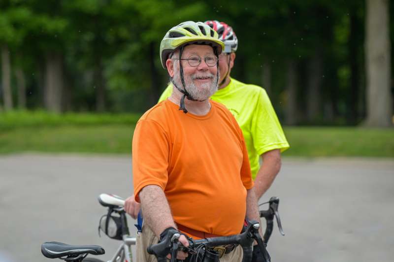 a man in an orange shirt with a helmet on his bike