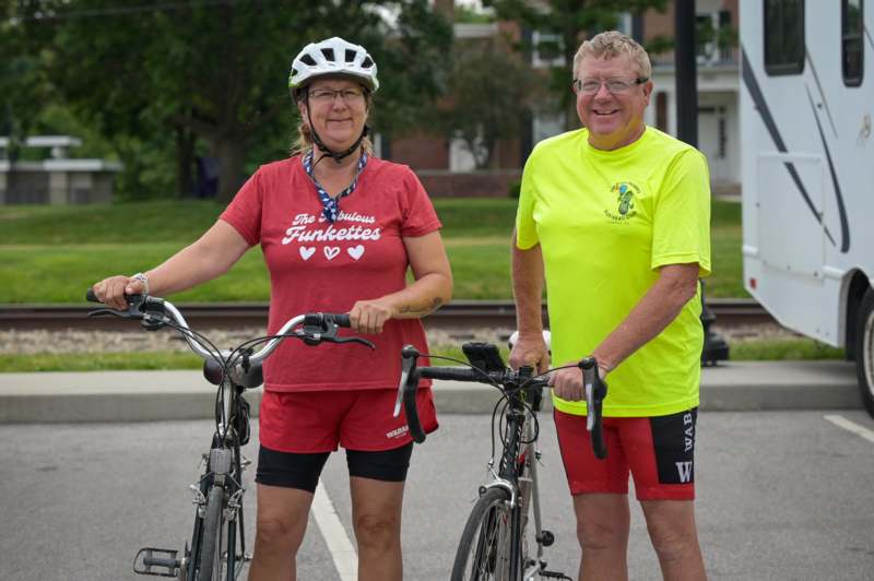 a man and woman standing next to bicycles