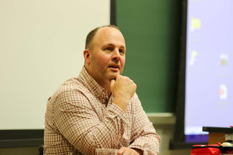 a man sitting in a chair with his hand on his chin