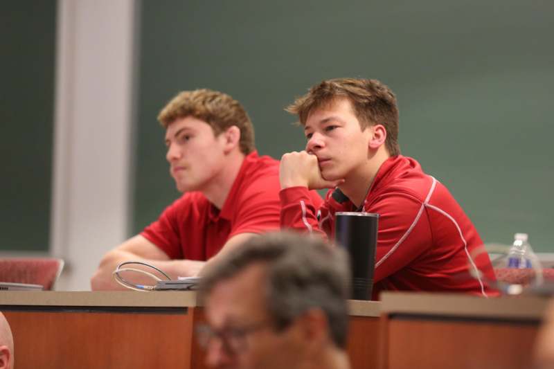 a group of men sitting at a desk