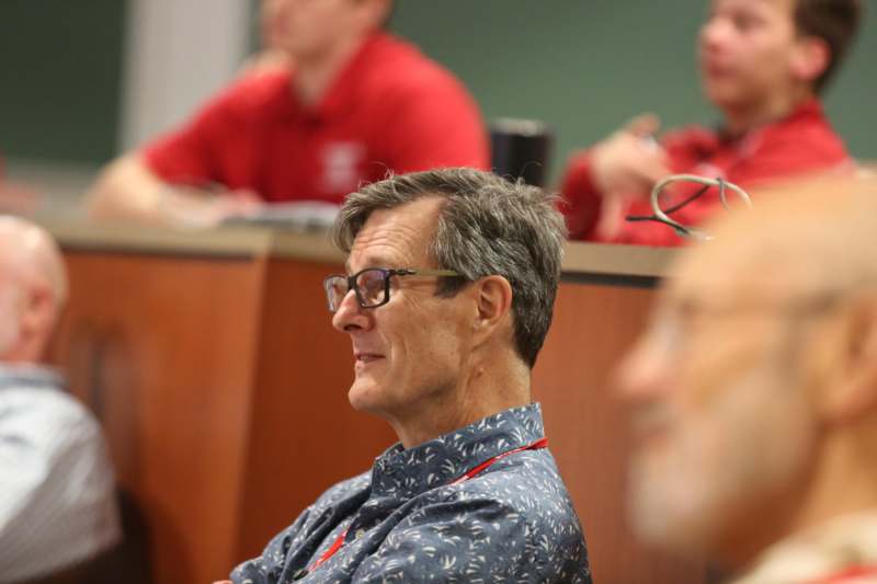 a man in glasses sitting in a room