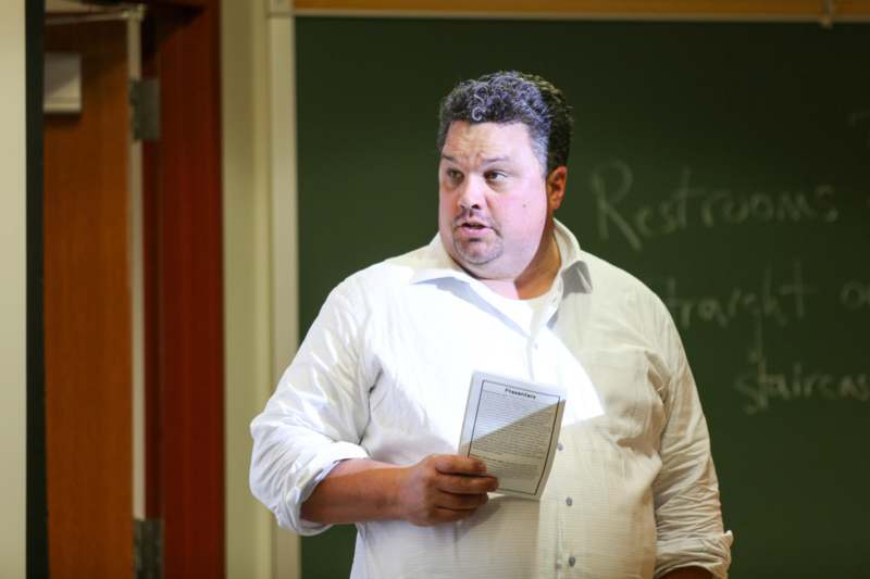 a man in a white shirt holding a piece of paper