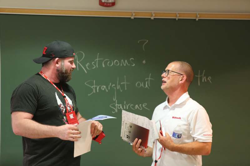 a group of men standing in front of a chalkboard