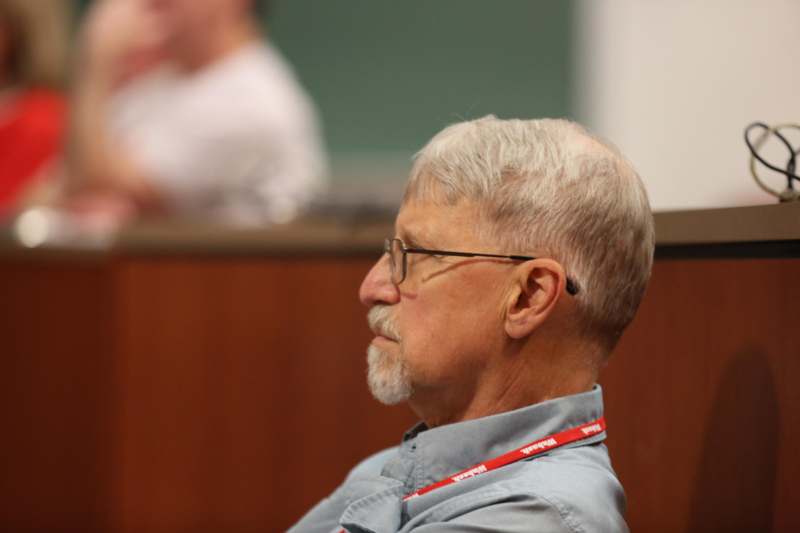 a man wearing glasses and a lanyard