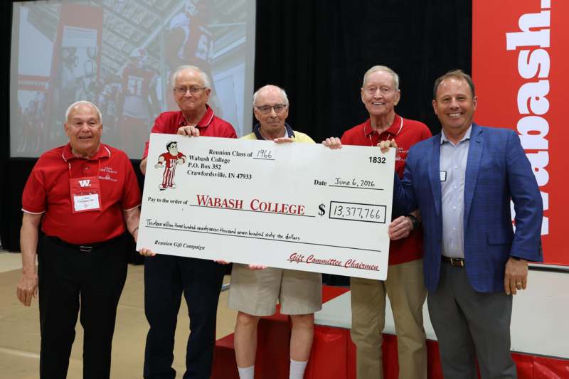 a group of men holding a large check