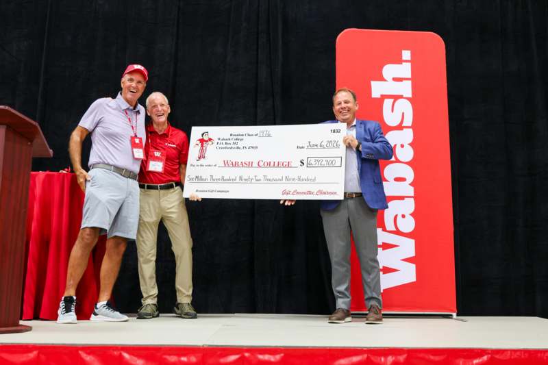 a group of men holding a check