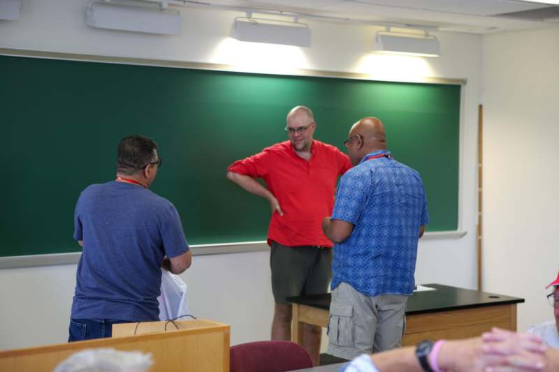 a group of men standing in front of a chalkboard