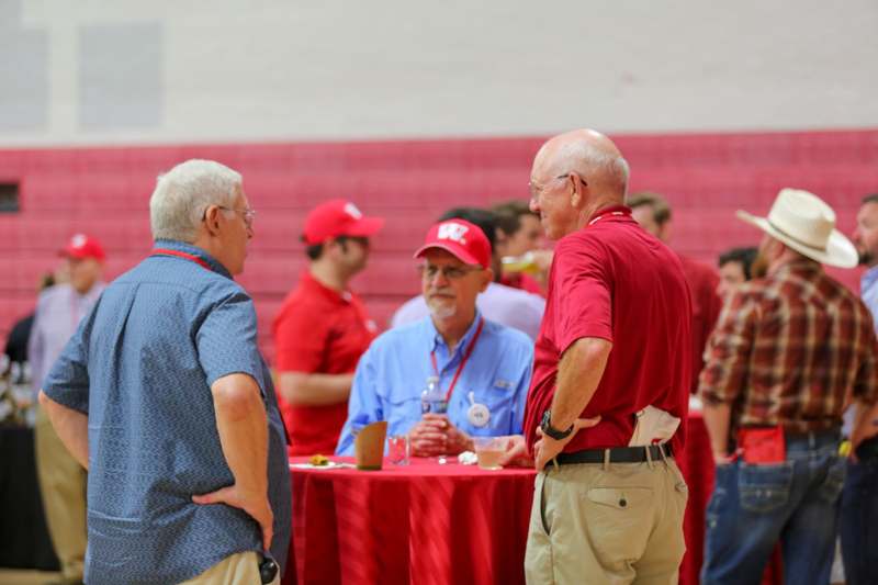 a group of men standing around a table