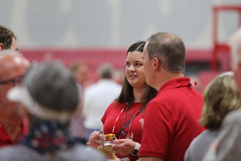 a woman in red shirt talking to a man