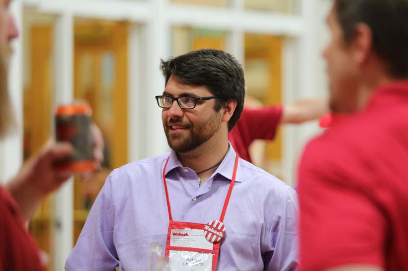 a man wearing glasses and a badge