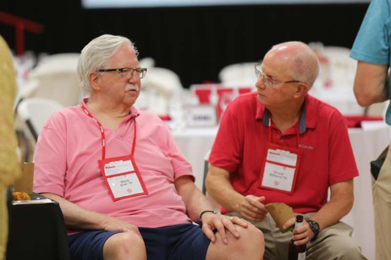two men sitting in chairs talking