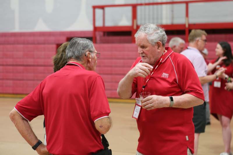 a group of men in red shirts talking