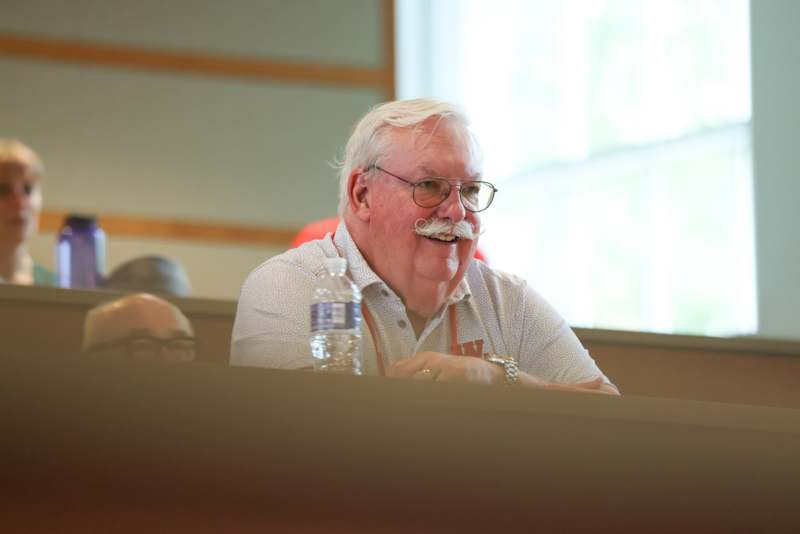 a man with a mustache sitting at a table