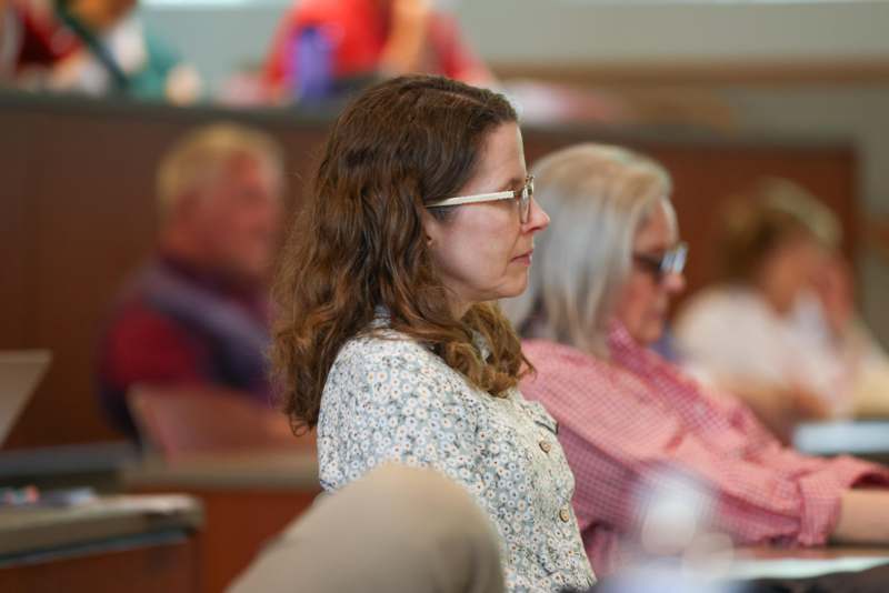 a woman in glasses sitting in a room