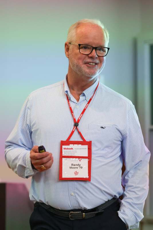 a man wearing a name tag and holding a phone