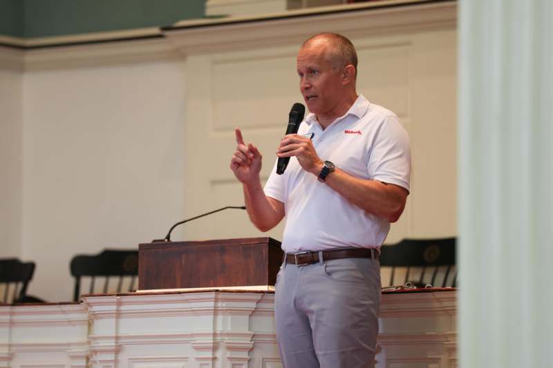 a man standing in front of a podium holding a microphone