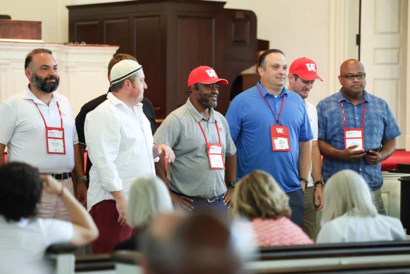 a group of people standing in a room with a group of people