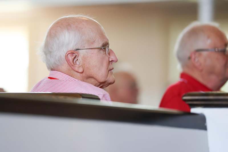 a man in red shirt sitting in a room