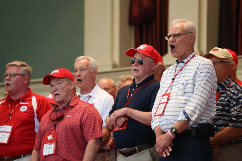 a group of people wearing red and white lanyards