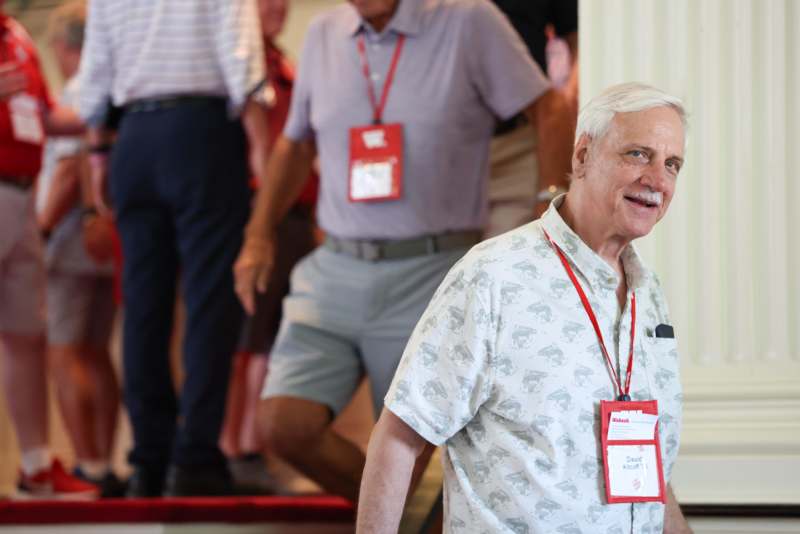a man wearing lanyards and a white shirt