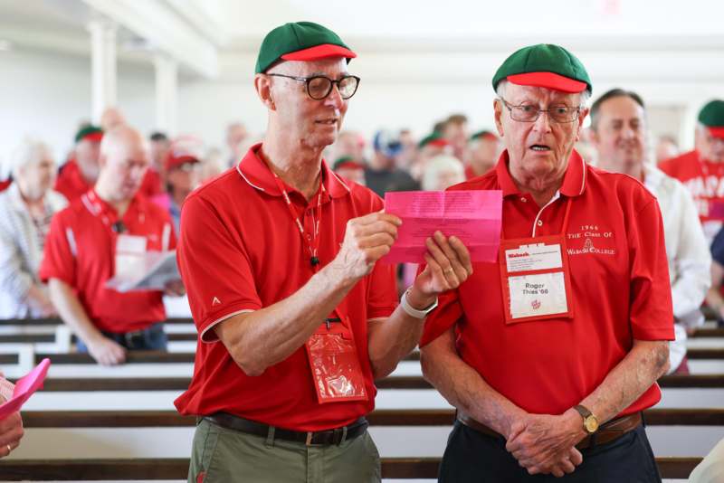 a group of men in red shirts and green hats