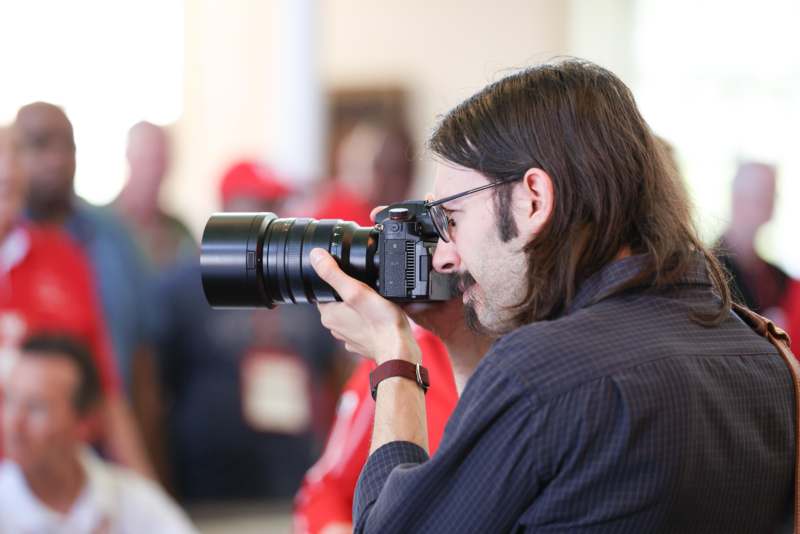 a man with long hair holding a camera