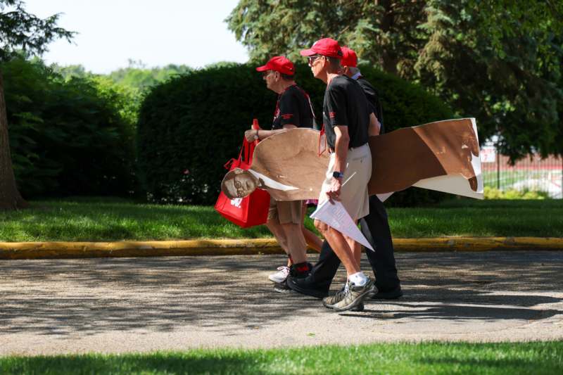 a group of men walking with cardboard wings and a bag