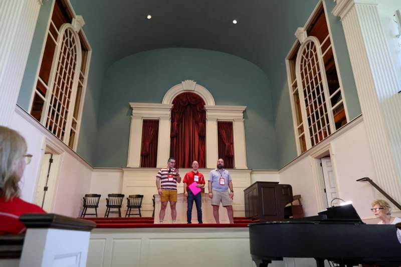 a group of men standing on a stage in a church