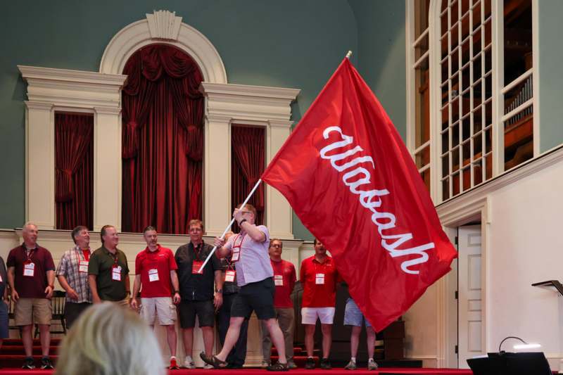 a group of people standing on a stage holding a flag
