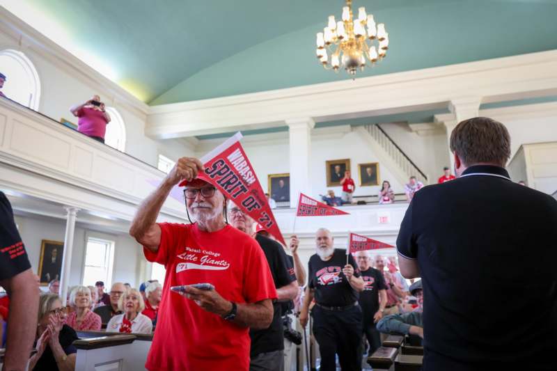a group of people in a room with a group of people holding flags