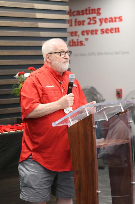 a man standing at a podium holding a microphone