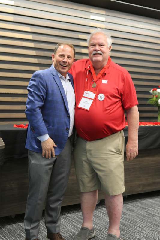 two men standing together smiling