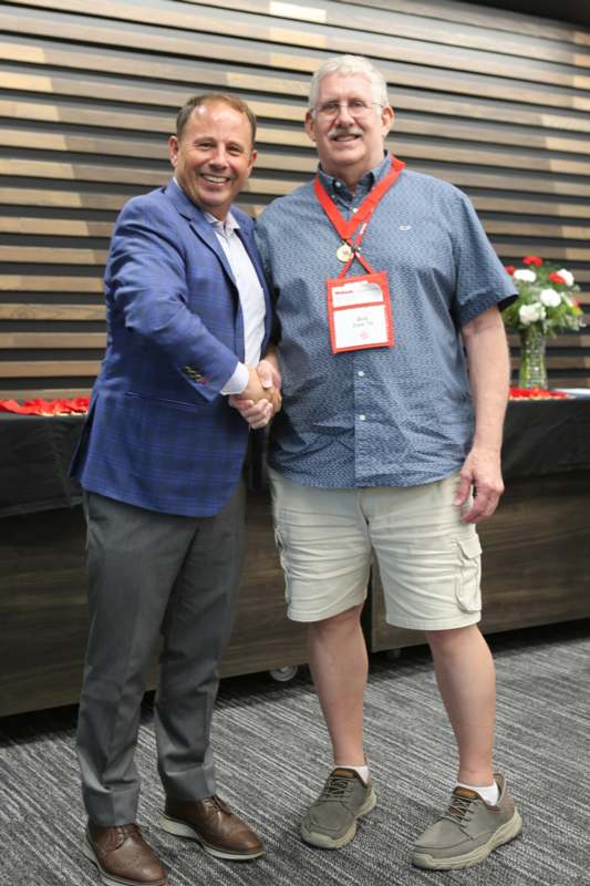 two men shaking hands in front of a table