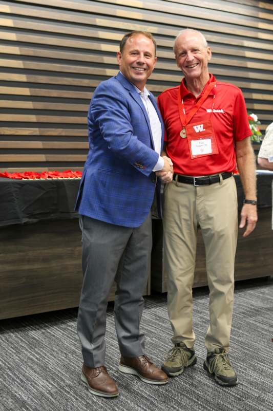 two men shaking hands in front of a table