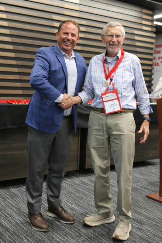 two men shaking hands in a room